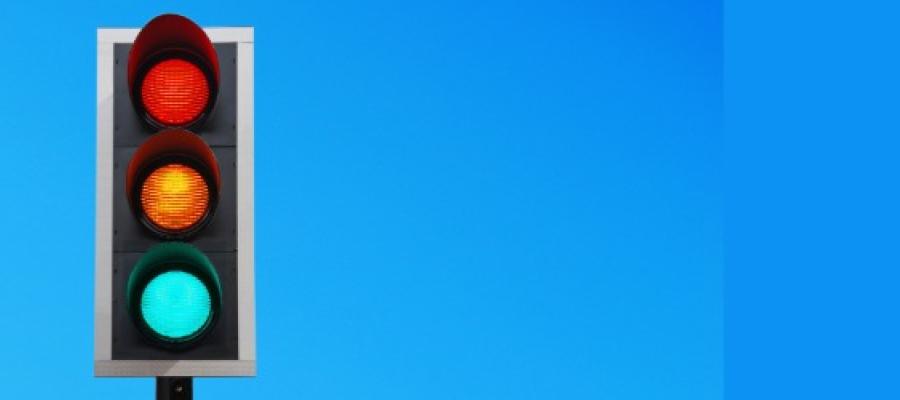 Traffic lights against a blue sky with green traffic light lit